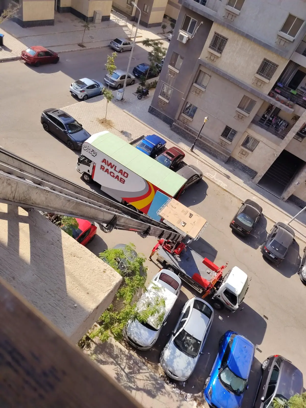 صينية ونش رفع الأثاث أثناء صعودها على السكة الهيدروليكية باتجاه بلكونة الشقة