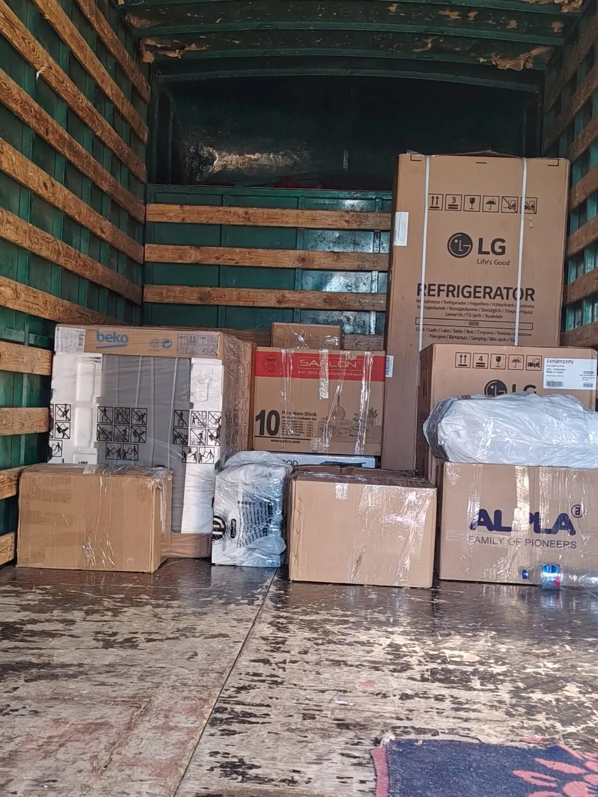 ثلاجة LG وأجهزة كهربائية وكراتين مرصوصة ومثبتة داخل شاحنة النقل